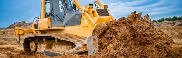 A bulldozer pushing a pile of dirt